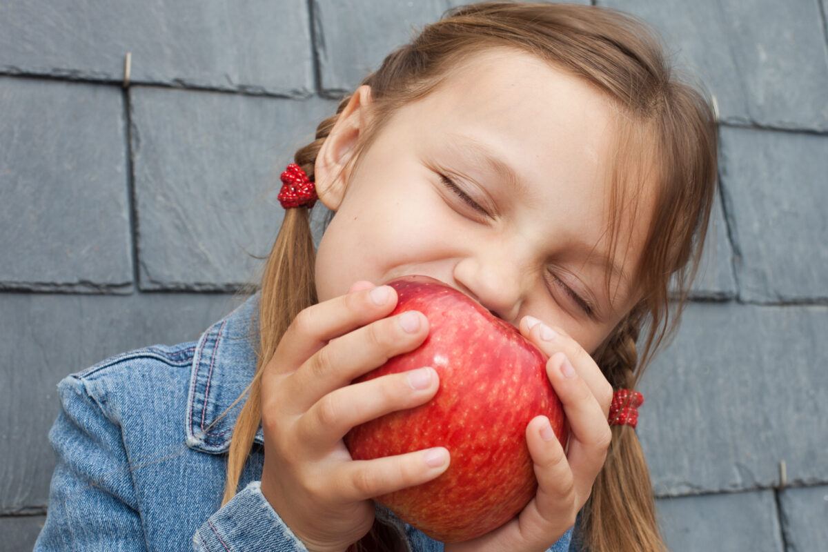 child enjoying biting an apple