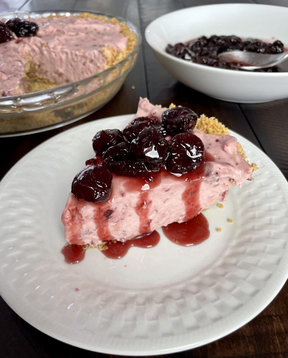 slice of no-bake cheese cake with cherry drizzle